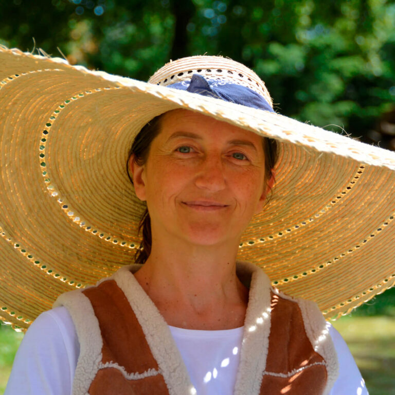 Gastgeberin Brita Waedt vom Scheunenloft Usedom im Garten mit großem Strohhut